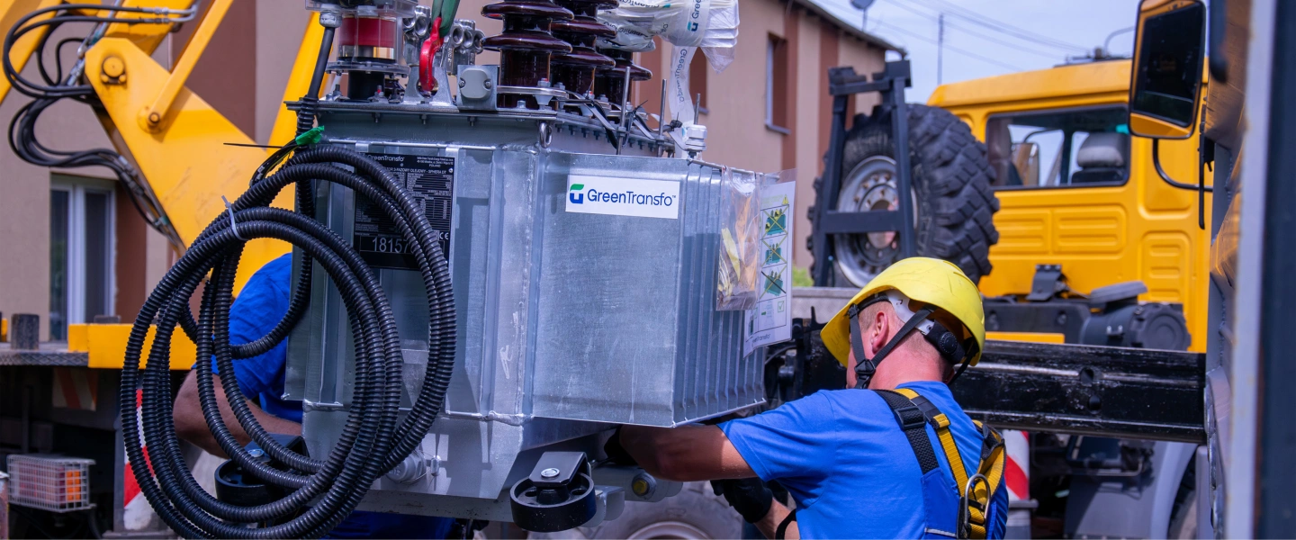 monter rozładowuje urządzenia energetyczne przy pomocy dźwigu 