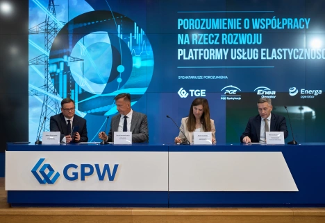 prezydium podpisujące dokumenty z ekranem LED w tle 