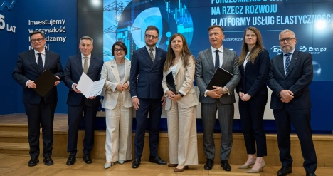 ludzie stojący na scenie z podpisanymi dokumentami 